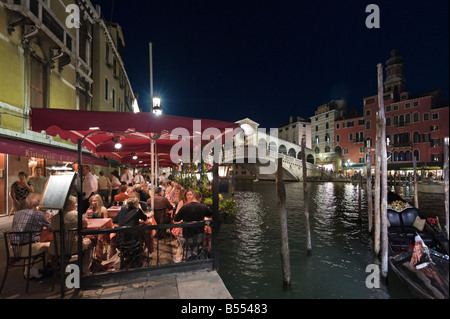 Restaurant and Gondolas at night on the Grand Canal near to the Rialto Bridge, Venice, Veneto, Italy Stock Photo