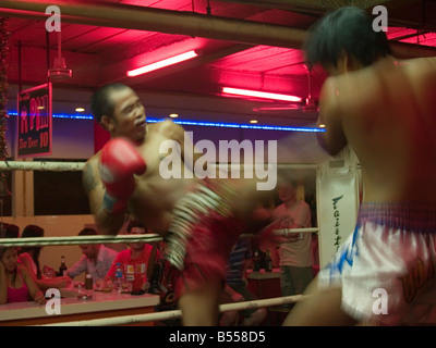 muay thai fighter lands a kick at fight in Thailand Stock Photo