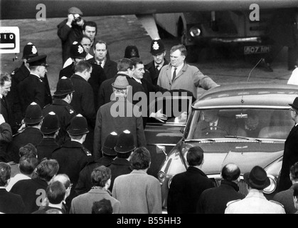 Great Train Robber Charles Wilson with a coat over his head getting into a Police car on the Tarmac at Heathrow Airport London after arriving from Canada. January 1968 P012526 Stock Photo