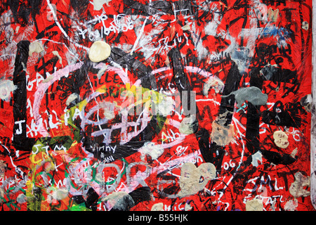 Grafitti on a wall Love written with black over red chewing gum names and all sort of grunge detail Stock Photo
