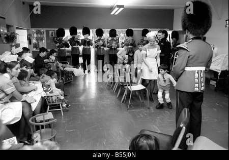 Part of the Coldstream Guards Band went to the children's ward at St. Thomas's London, and played their band music to the kiddies. The soldiers played Christmas Carols and happy marches. Some of the children even played some of the musical instruments. The nurses, children and soldiers joined in musical chairs. Then they all had tea, and the Tots Tattoo drew to a close. Leading the musical chairs is Hamid Shobali from Saudi Arabia who is being treated for deformity of the feet. The treatment is in the form of progress correction. December 1969 Z12127-003 Stock Photo