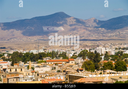 View over the city of Northern Nicosia Turkish Republic of Northern Cyprus toward Turkish flag on mountain Stock Photo