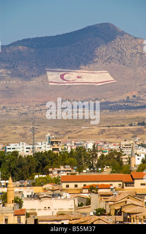 View over the city of Northern Nicosia Turkish Republic of Northern Cyprus toward Turkish flag on mountain Stock Photo