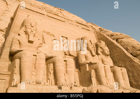 The four massive colossal statues of the Pharaoh decorate facade of the Great Sun Temple Of Ramses II in Abu Simbel rock temples. Southern Egypt Stock Photo