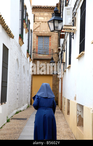 Nun walks down an empty narrow street in old Cordoba Stock Photo