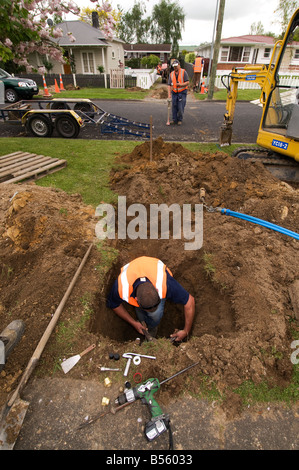 man connecting underground water pipes Stock Photo