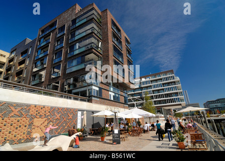 Modern buildings at Kaiserkai and the view along the Dalmannkaipromenade with pedestrians passing the Café Kaiser´s at the new H Stock Photo