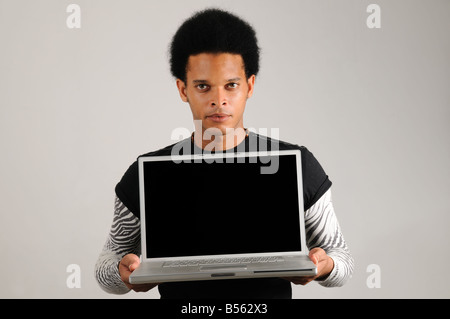Portrait of young trendy latino man holding modern laptop computer Stock Photo