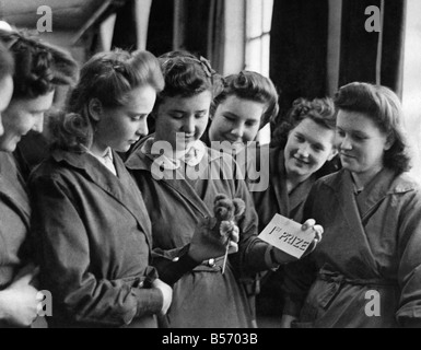 World War II Home front: 14 year old Eileen Gearing shows some admiring rivals her 1st. Prize miniature Teddy Bear. During a break at the munnitions factory. March 1944 P010158 Stock Photo