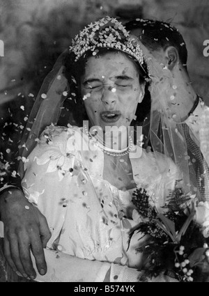 It's raining confetti. The happy bride under the barrge of confetti is 19years old Marion Clay of Steyning Grove, Mottingham, kent. As she left St. Edwads Church near her home, on the arm of her bridegroom 24 years old Robert Richards, a radio engineer of Bromley the guests waited their moment. Then swoosh......the confetti came hurtling over them to fall in a cascade. It was the finishing touches to a great day, when the couple start out together. They have a caravan home waiting for them at Green Street Green, and they have waited two years for this day. December 1952 P009051 Stock Photo