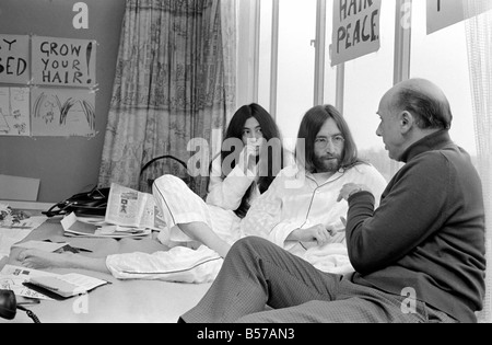 Pictured on their honeymoon bed newly weds. John Lennon and Yoko talking to Donald Zec about their seven day event at the Amster Stock Photo