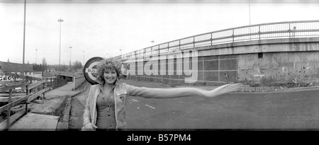 Model Angela Jay pictured here near her home in Hendon trying to stop a bus. The stretching of her arm is not done physically but photographically.;January 1975 ;75-00175-001 Stock Photo