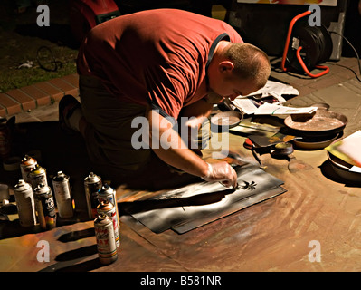Pavement artist working with spray paints and charcoal at night seaside resort of Leba Poland Stock Photo
