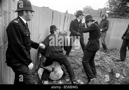 Lewisham Riot 1977 : Police officers subdue and arrest one of rioters from the centre of Lewisham following clashes between extremists on the Right and Left. The riot was sparked by a National Front march through the centre of town, which was confronted by a left wing counter demonstration. August 1977 77-04357-022; Stock Photo