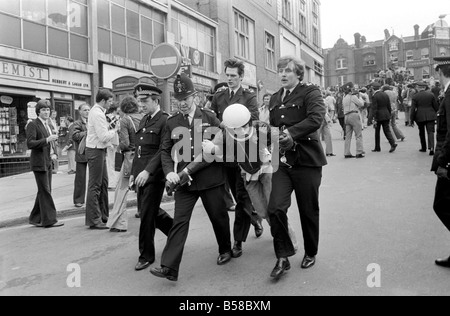 Lewisham Riot 1977 : Police officers carry off one of rioters from the centre of Lewisham following clashes between extremists on the Right and Left. The riot was sparked by a National Front march through the centre of town, which was confronted by a left wing counter demonstration. August 1977 77-04357-033 Stock Photo