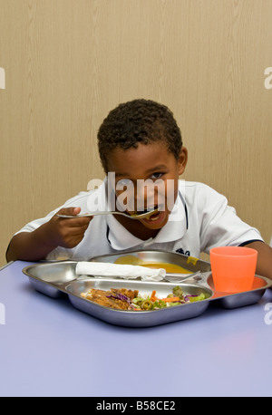 Infant boy having a healthy balanced lunch in his kindergarten school canteen Stock Photo