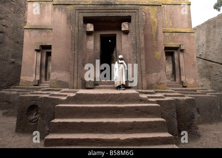 A priest stands at the entrance to the rock-hewn church of Bet Giyorgis (St. George), in Lalibela, Ethiopia, Africa Stock Photo