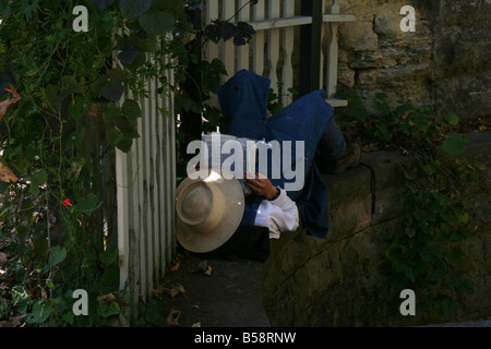 A man lying in the shade reading a bible. Stock Photo
