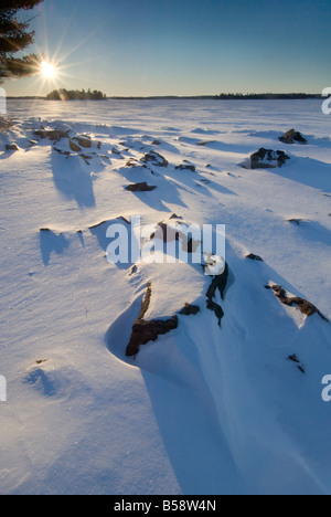 Sunrise on a snow covered, frozen lake during winter Stock Photo