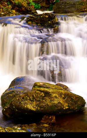 water cascading over rocks in a waterfall Stock Photo