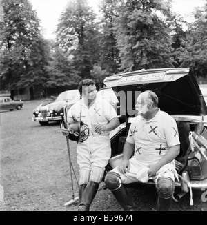 Polo: Jimmy Edwards captained the 'Whocko' polo team that was beaten by 'The Troubleshooters' at Ham Polo Club. Polo player David Healy and Jimmy Edwards have a breather during half time, sitting on the end of a car. July 1970 70-6886-004; Stock Photo