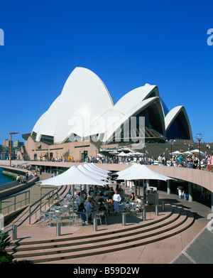People at cafe tables outside the Opera House UNESCO World Heritage Site Sydney New South Wales Australia Pacific Stock Photo