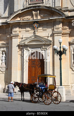 A Karrozzin stands in front of 'St Paul's church Rabat' in Malta. Stock Photo