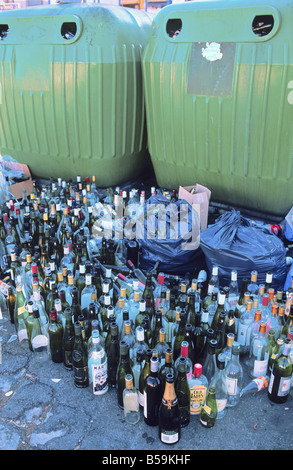 Empty glass bottles dumped in front of overflowing bottle banks, Sète, Hérault, Languedoc, France, Europe, Stock Photo