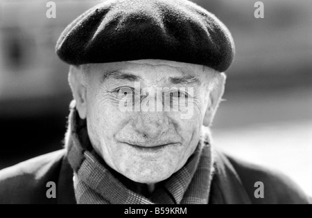 An old man of Paris wearing beret, scarf and coat on a cold day in ...