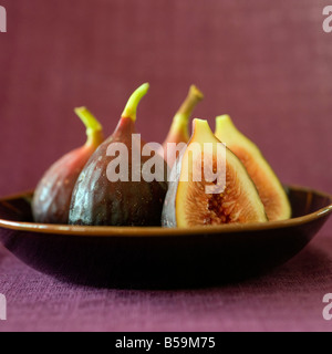 still life three whole figs and one sliced in a japanese bowel Stock Photo