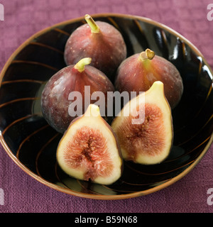 still life three whole figs and one sliced in a japanese bowel Stock Photo
