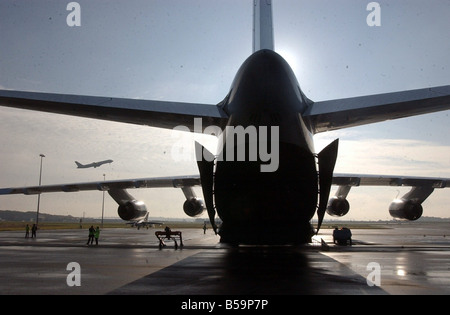 A conventional airliner is dwarfed by the engines and wing of the Antonov freight plane at Newcastle Airport Stock Photo