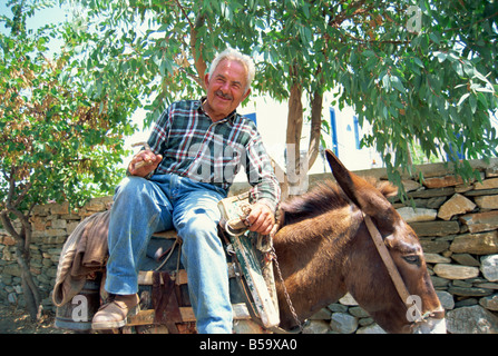 Portrait of a smiling man sitting on his donkey on Sifnos Cyclades Islands Greek Islands Greece Europe Stock Photo