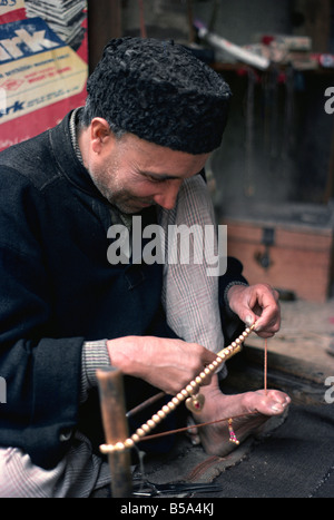 Man stringing beads Srinagar Kashmir India Asia Stock Photo