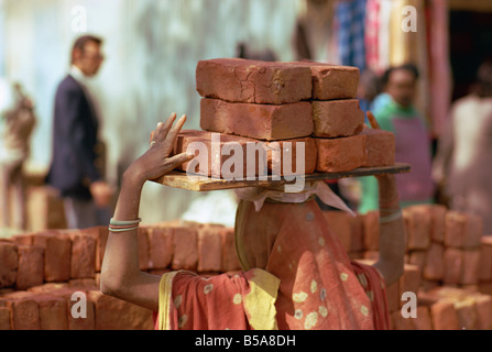Woman construction worker carrying bricks on her head Delhi India Asia Stock Photo