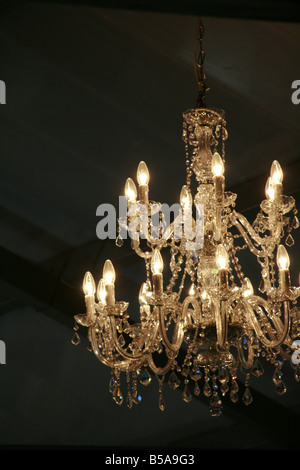 elegant glass chandelier light fitting in dark room Stock Photo