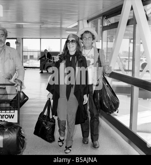 Pop eyed Marty Feldman with a spring onion in his lapels keep away plastic vampires flew back to London with his wife Loretta on Stock Photo