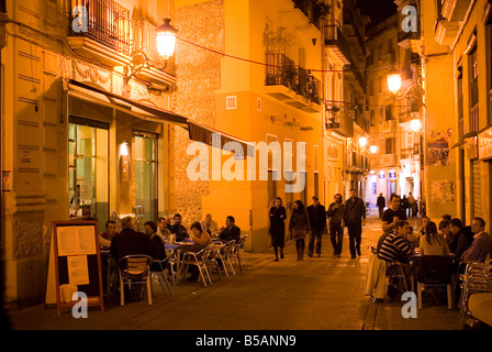 People eating outside in a Restaurant in Calle Roteros in the historical city centre of El Carmen in Valencia Spain Stock Photo