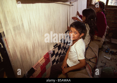 Young children weaving carpets for up to 16 hours a day in carpet factories, Jawlikhel, Kathmandu, Nepal Stock Photo