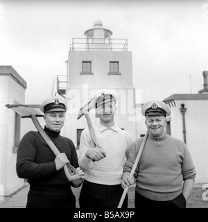 The lighthouse keepers and their families go about their daily duties around The Strathy Point Lighthouse. These include cleaning the lamp, maintaining the foghorn and looking after the garden. 1960 A797-004 Stock Photo