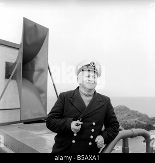 The lighthouse keepers and their families go about their daily duties around The Strathy Point Lighthouse. These include cleaning the lamp, maintaining the foghorn and looking after the garden. 1960 A797-007 Stock Photo