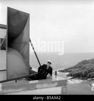 The lighthouse keepers and their families go about their daily duties around The Strathy Point Lighthouse. These include cleaning the lamp, maintaining the foghorn and looking after the garden. 1960 A797-008 Stock Photo