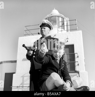 The lighthouse keepers and their families go about their daily duties around The Strathy Point Lighthouse. These include cleaning the lamp, maintaining the foghorn and looking after the garden. 1960 A797-011 Stock Photo