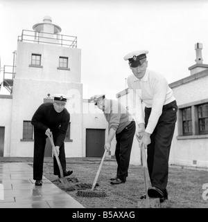 The lighthouse keepers and their families go about their daily duties around The Strathy Point Lighthouse. These include cleaning the lamp, maintaining the foghorn and looking after the garden. 1960 A797 Stock Photo