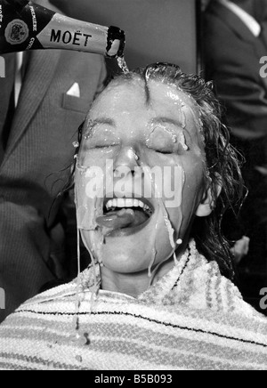 Meet Anne Aubrey who is celebrating her 24th birthday with a champagne hair rinse in a Baker Street Salon. At a cost of 30/- a bottle the hair do was sparkling. Bubbly champagne ran down her face, and she simply had to put her tongue out to catch the drops. Anne is leaving early in February for Pretoria S. Africa where she is to work on a film about the pioneers of Africa called 'The Hellions'. This is a British film of the Western type, in period costume. February 1961 P007932 Stock Photo