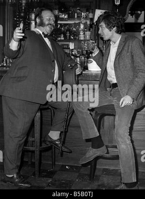 Scott Walker American singer songwriter and 1967 Sixties pop group singer of The Walker Brothers has a drink and a joke with landlord Bruce Calder at the Windsor Castle pub London Stock Photo