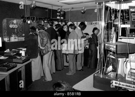 Beat the Budget shopping spree in Tottenham Court Road, London, street of radio and Hi-fi. ;Customers looking at goods in an electrical store;April 1975 ; Stock Photo