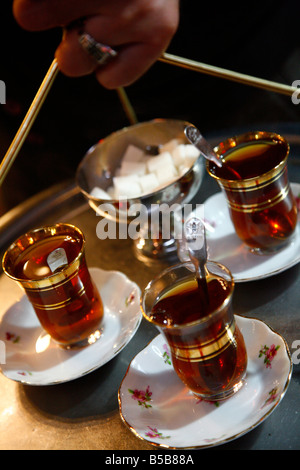 Hand holding a tray with Turkish tea, Istanbul, Turkey, Europe Stock Photo