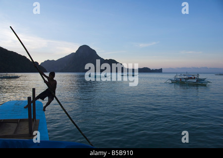 Young boy punting boat, Cadlao Island, Bacuit Bay, El Nido Town, Palawan Province, Philippines, Southeast Asia Stock Photo