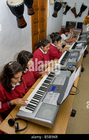 MUSIC CLASS KEYBOARDS Teenage students practice together on electronic keyboards in school music classroom Stock Photo